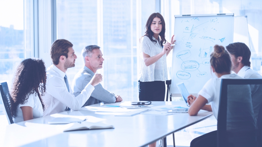 Reunião de equipe ao redor de um quadro