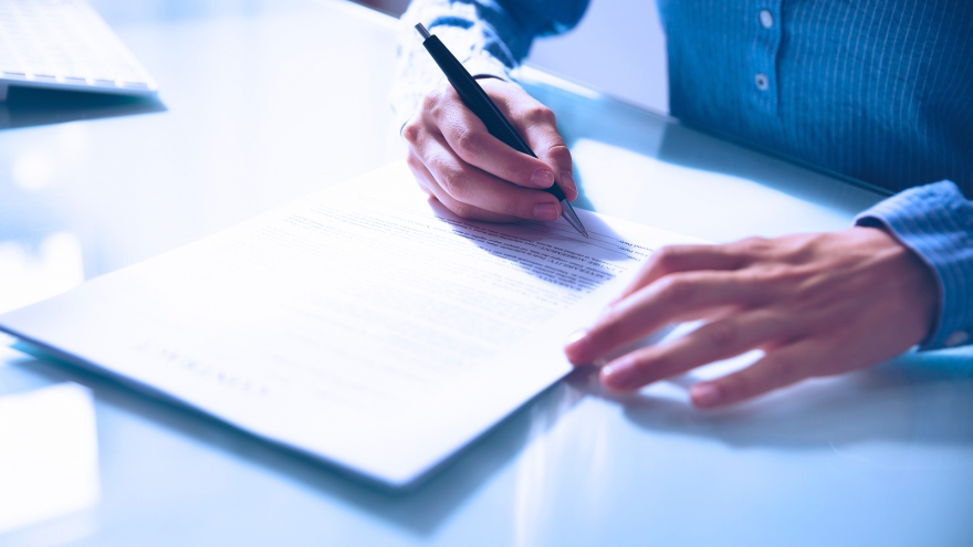 Homem escrevendo em um caderno sobre uma mesa